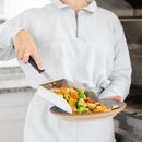 A person using an XL Stainless Steel Griddle Shovel – 5 Cup Food Scoop & Spatula to serve cooked vegetables from a pan onto a plate.