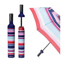 The Vinrella Striped Kaido Bottle Umbrella features a blue, purple, pink, and white striped design with a wine bottle-shaped case. Shown open and closed, its no-drip design keeps you dry and stylish on rainy days.